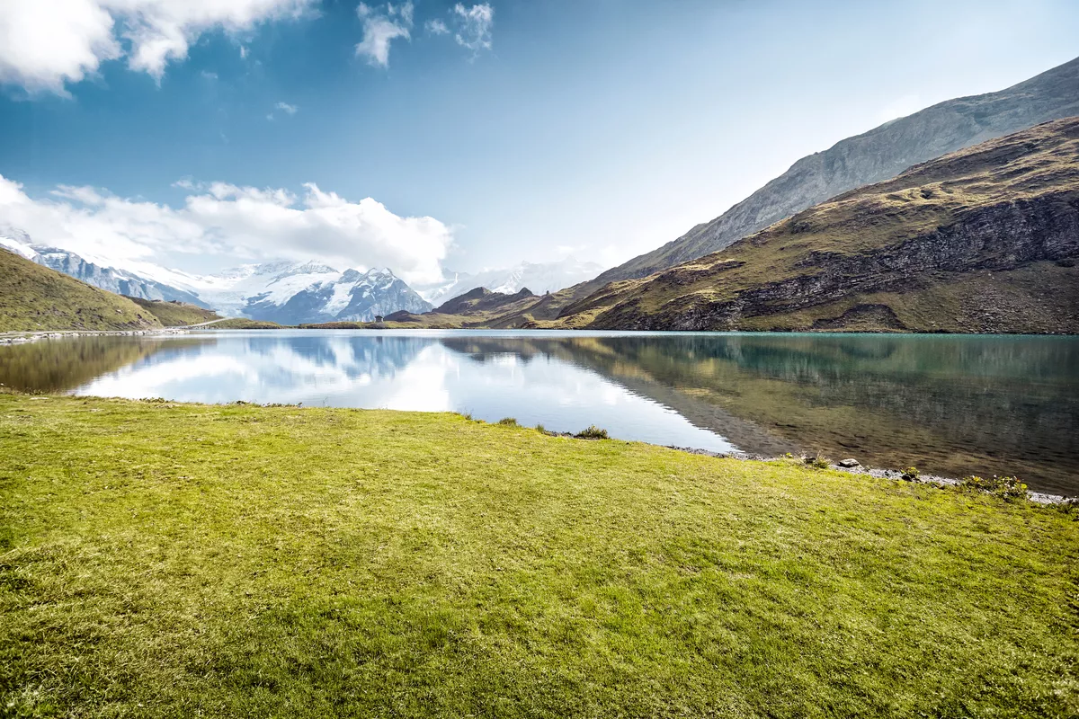 Photo of a beautiful natural landscape. There is a lake with mountains surrounding it