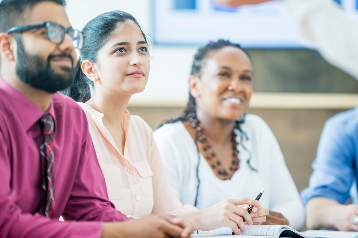 Group of four diverse friends sitting in a meeting tallking to each other