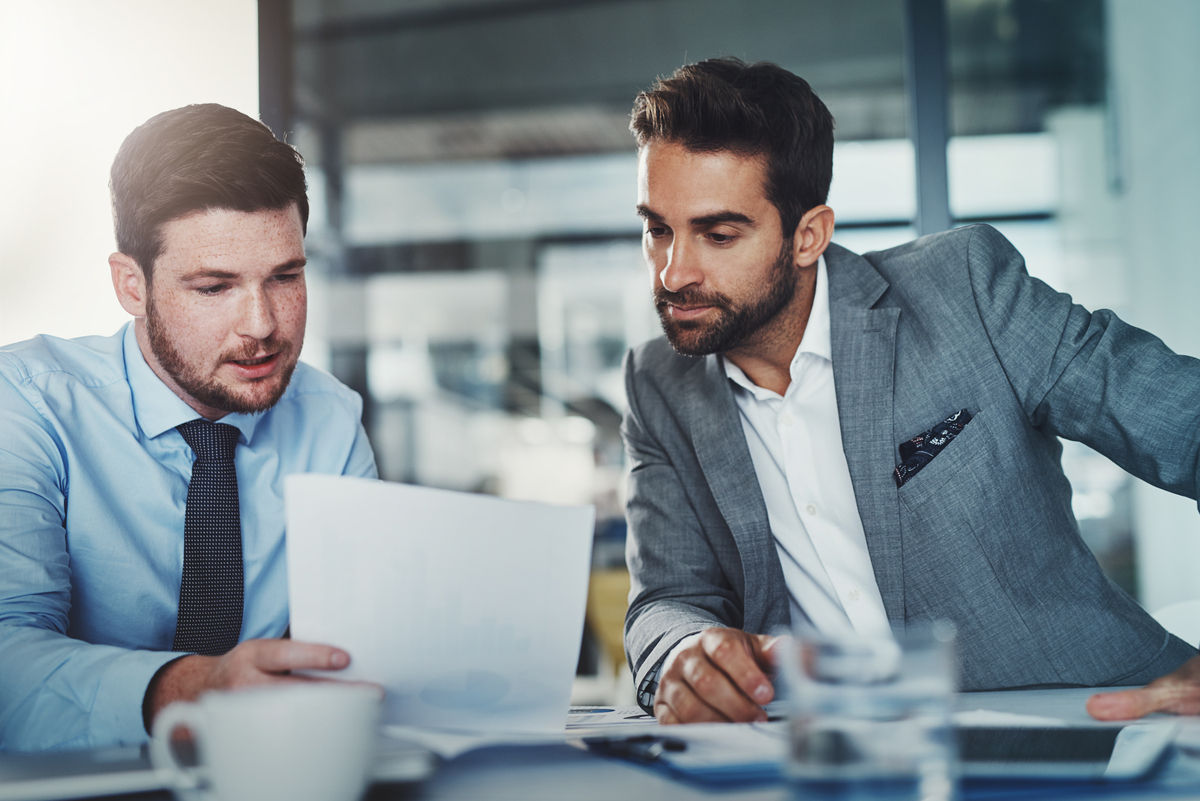 Two business people looking over a paper while having coffee