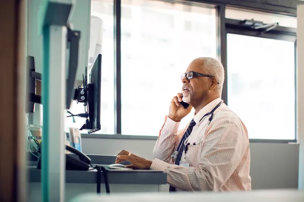 Provider on a cell phone while sitting at a desk