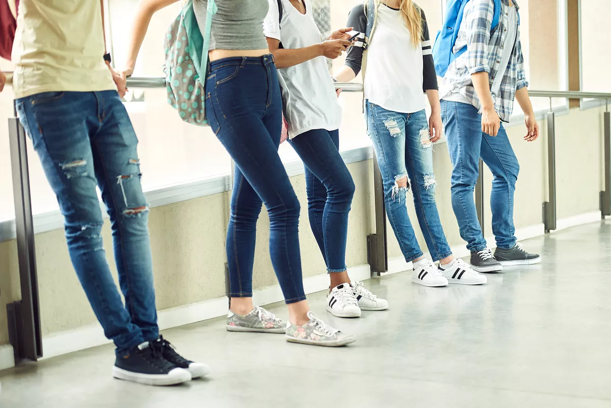 Group of people standing in a line. The shot only shows from their chest down