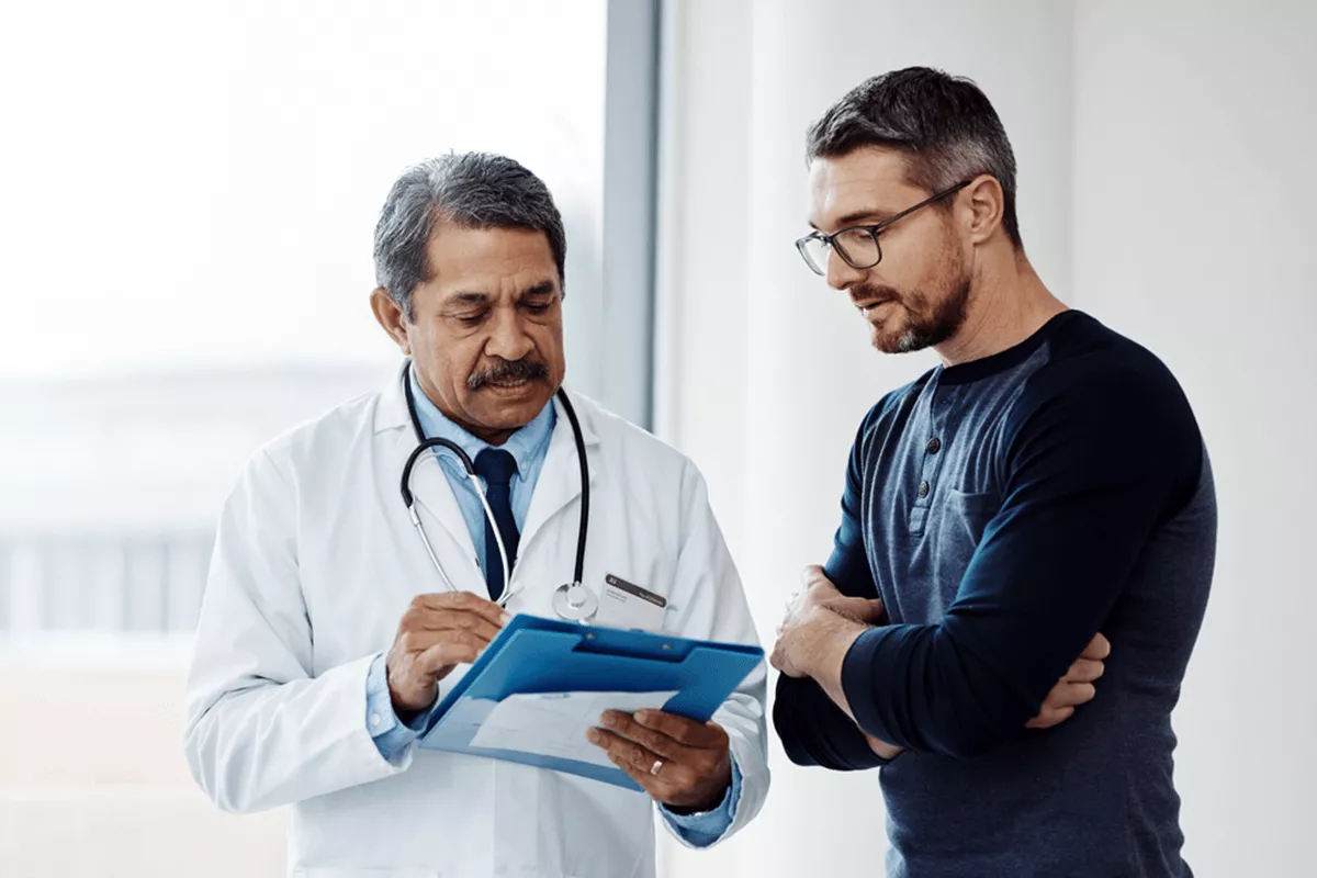 Provider holding chart while talking to a patient