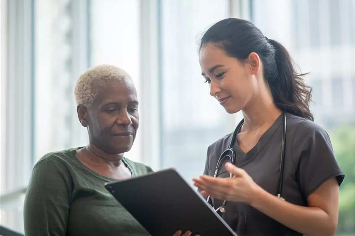 Provider talking to a patient about her results. The provider is holding a tablet