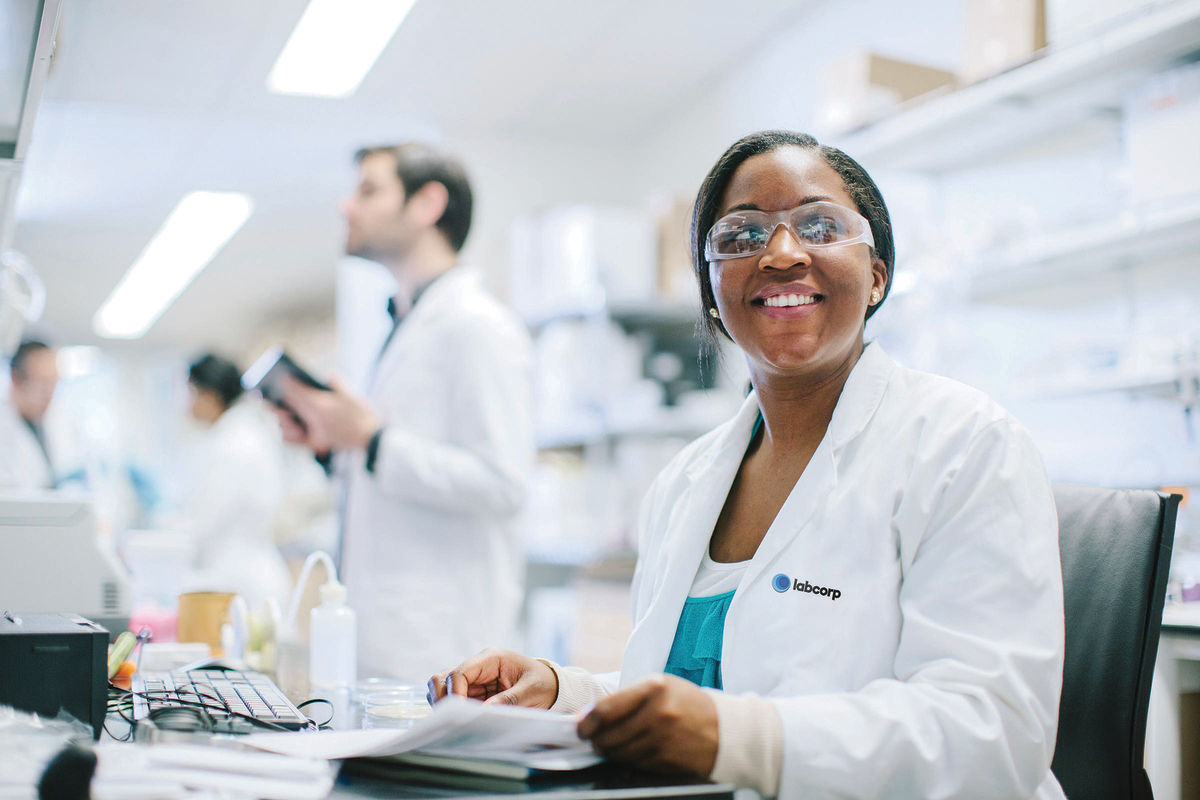 Woman sitting in a lab with a smile on her face.