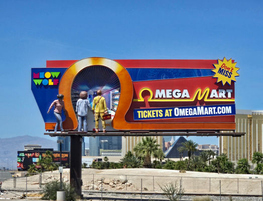 A 3D Lamar billboard in Las Vegas promotes Meow Wolf’s Omega Mart with oversized dimensional elements, including a storefront-style entrance, sculpted figures, and bold “Don’t Miss” signage.