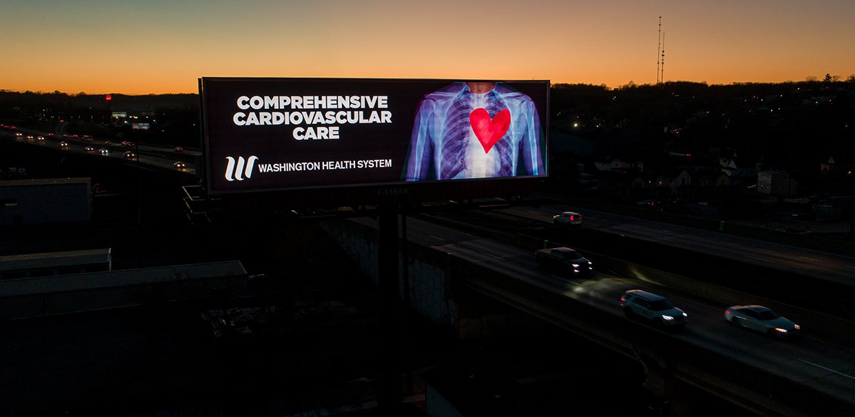 Washington Health System billboard at night that reads, "Comprehensive Cardiovasular Care"