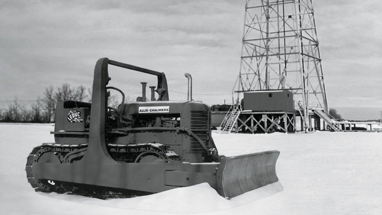Black and white photo of bulldozer in front of tower