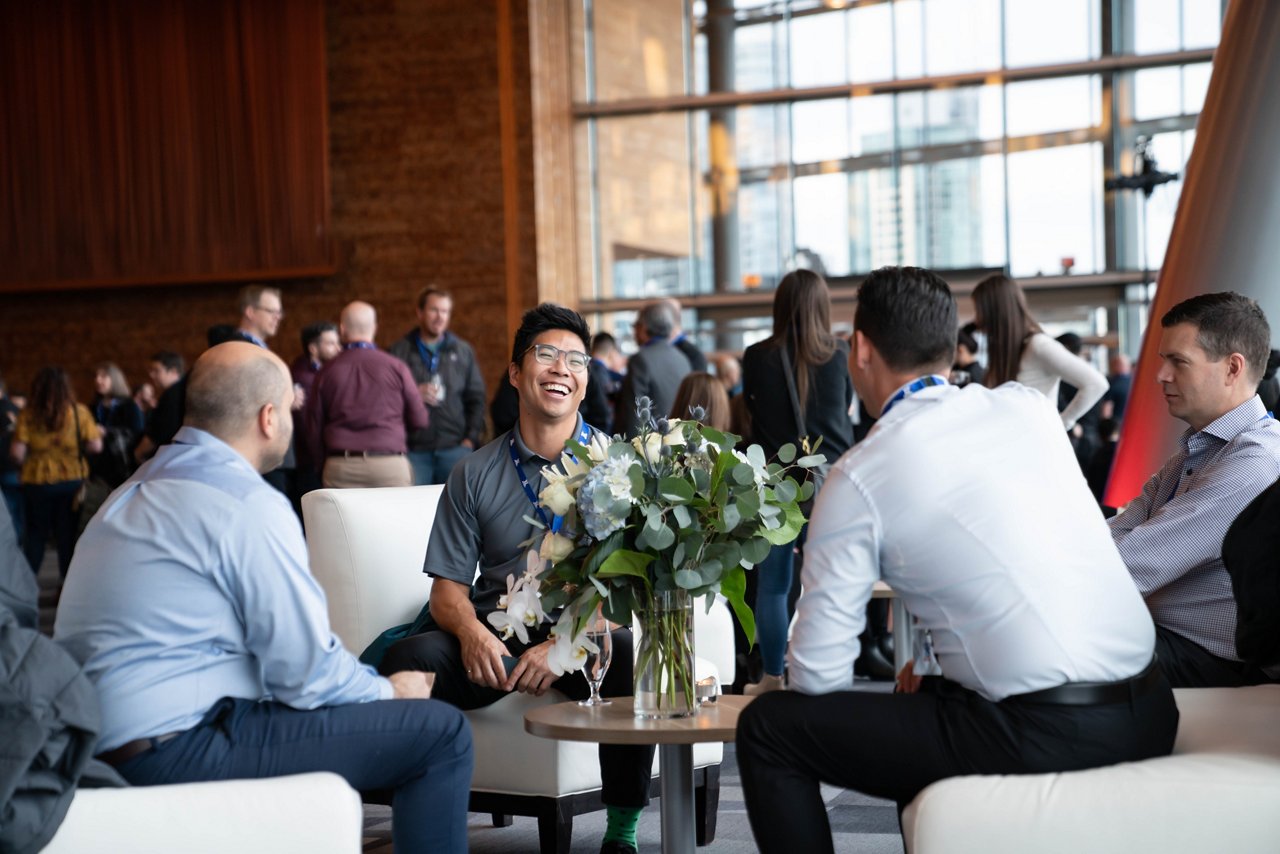 Group of people sitting around talking in a large lounge area