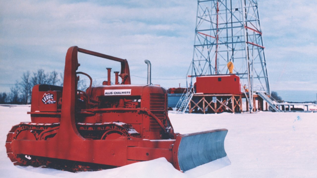 Bulldozer in snow sitting in front of large tower