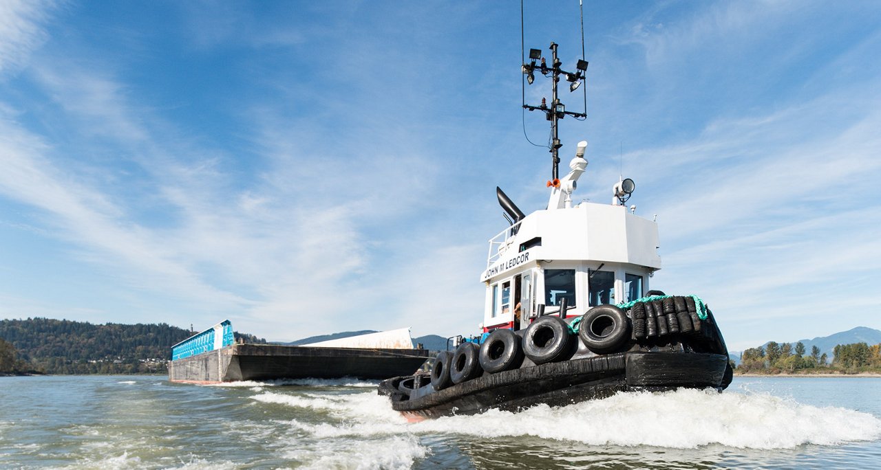 Tugboat pulling barge across the water