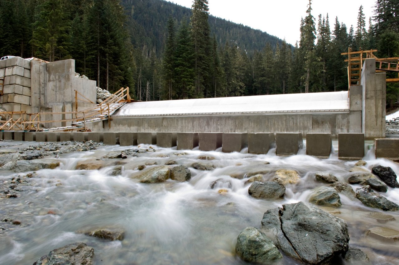 water flowing over rocks into dam facility