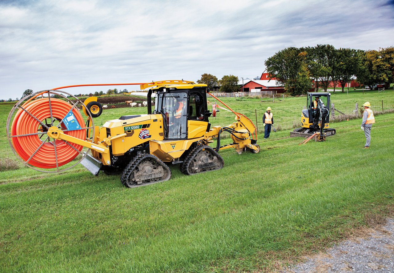 tractor running water line along field