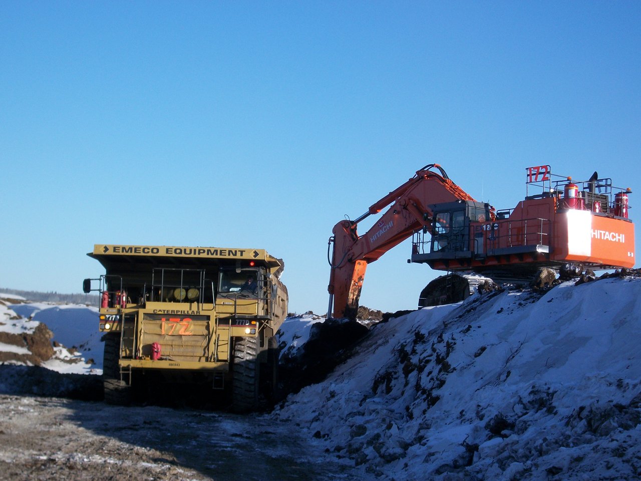 Excavator with dumping truck clearing the road.