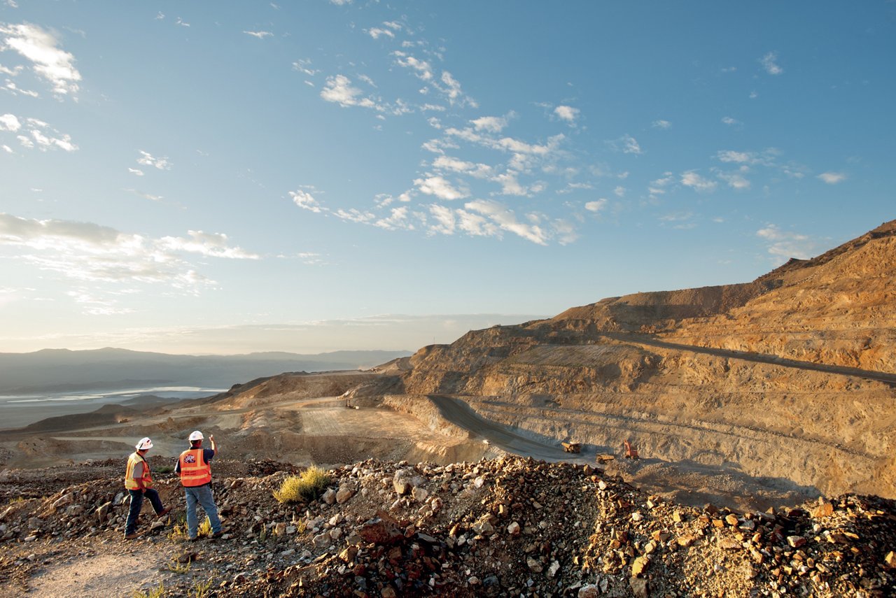 Two workers wearing saftey gear overlooking mountain road