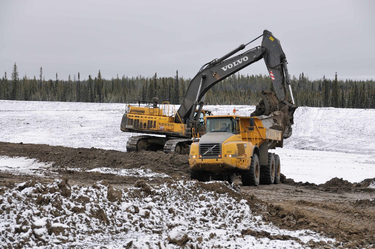 Excavator with dumping truck clearing the road.