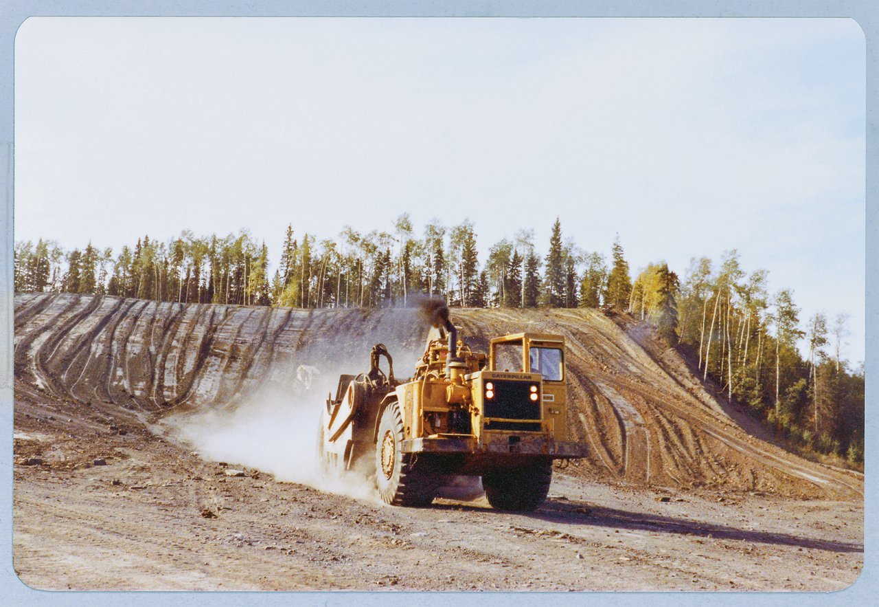 Large machine moving dirt up  hill