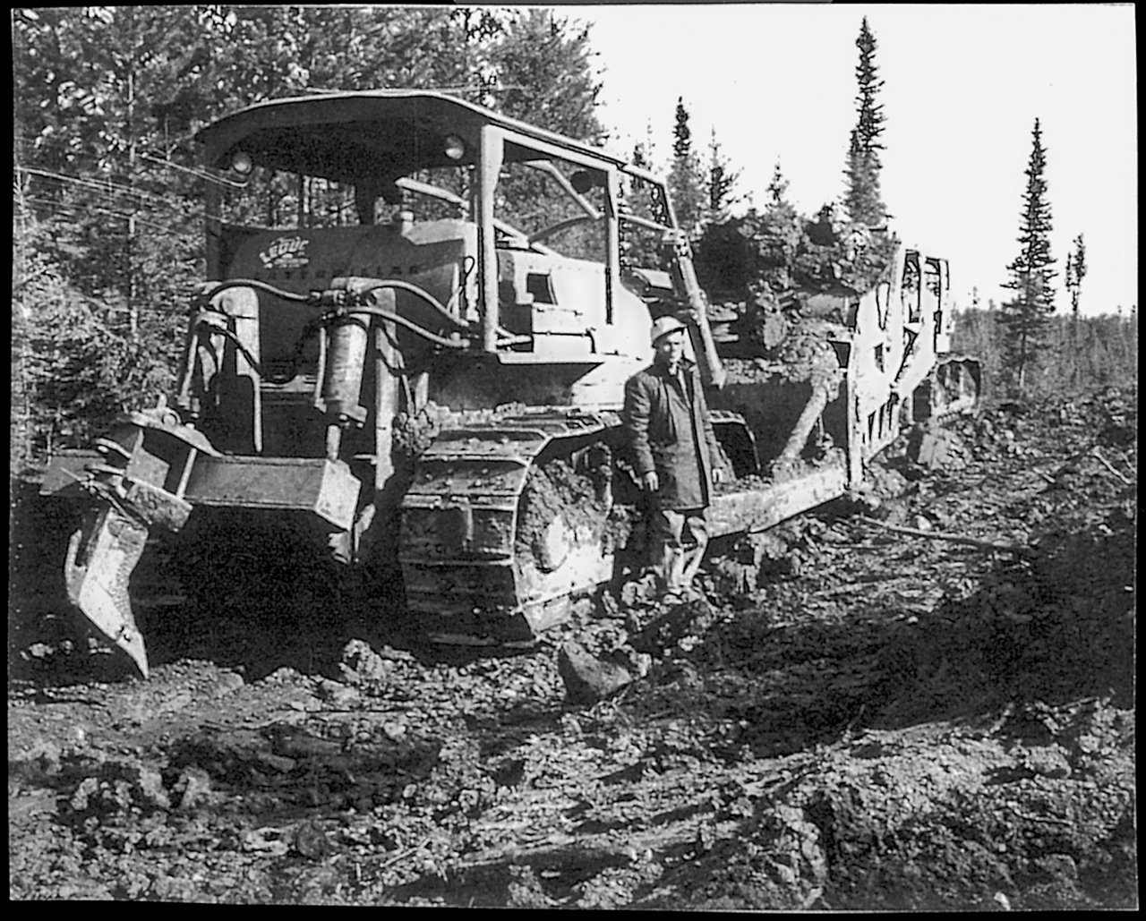 large machine cutting dirt and rocks from new road