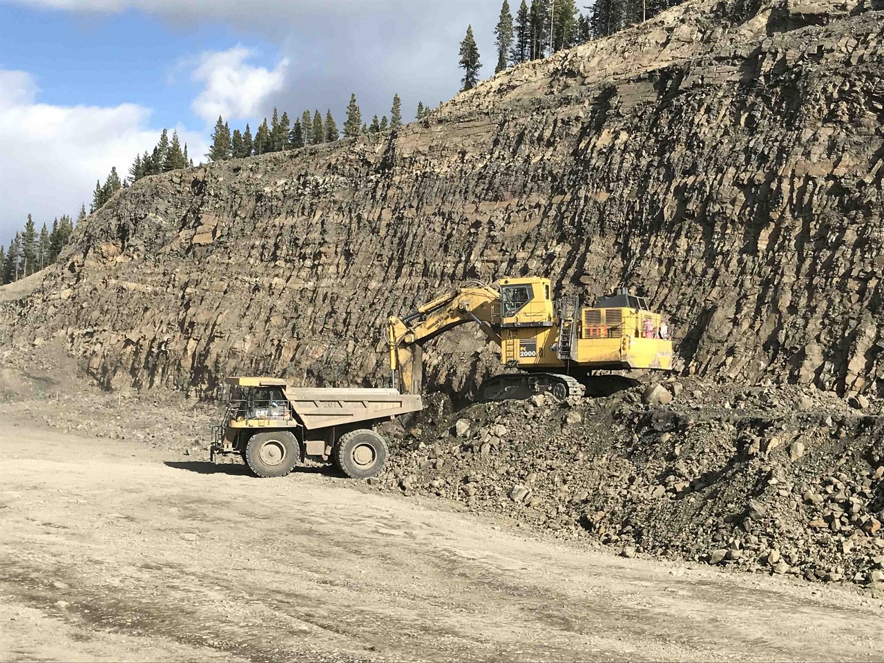 Excavator with dumping truck clearing the road.