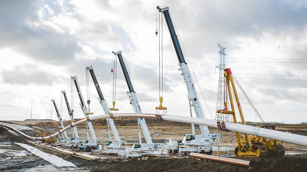 Wide shot of pipe layers and heavy machinery on-site