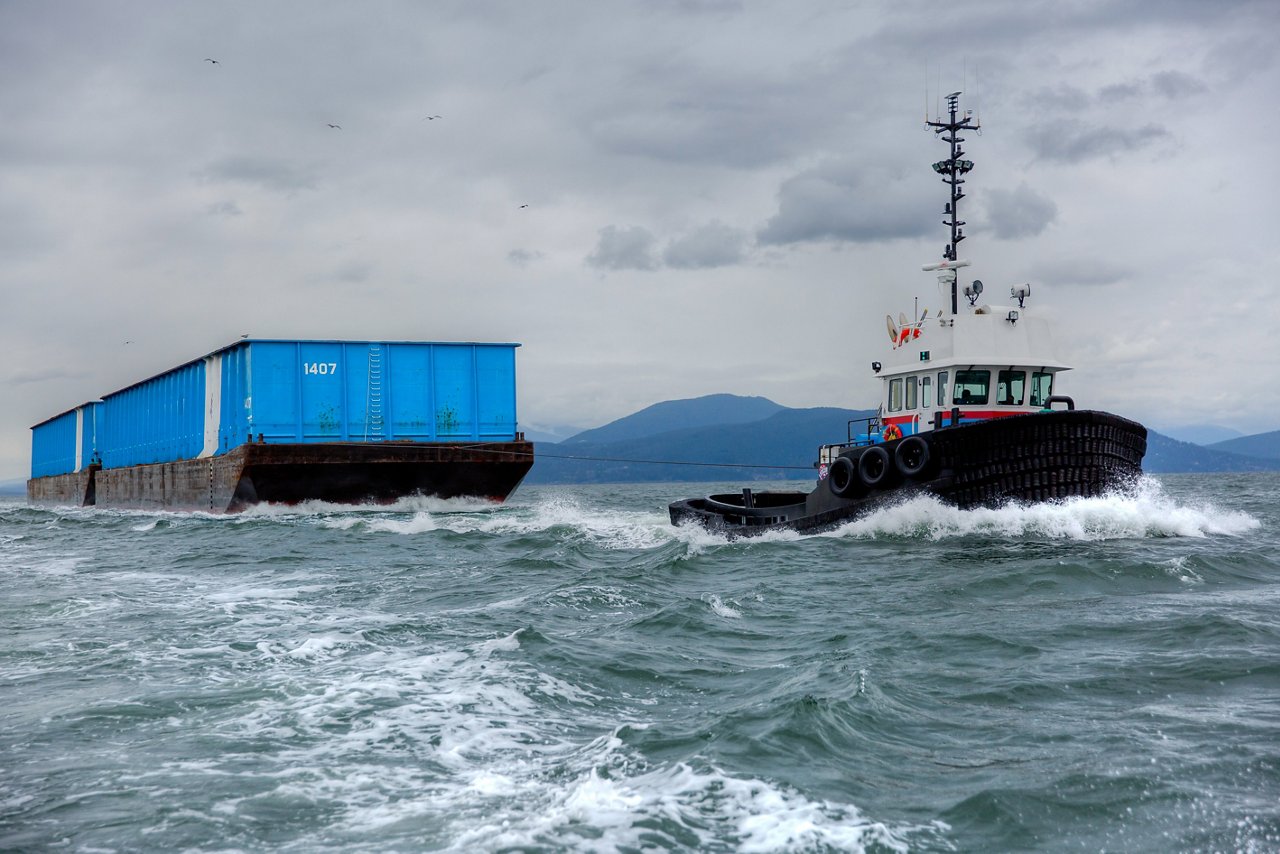 Tugboat with two barges in water