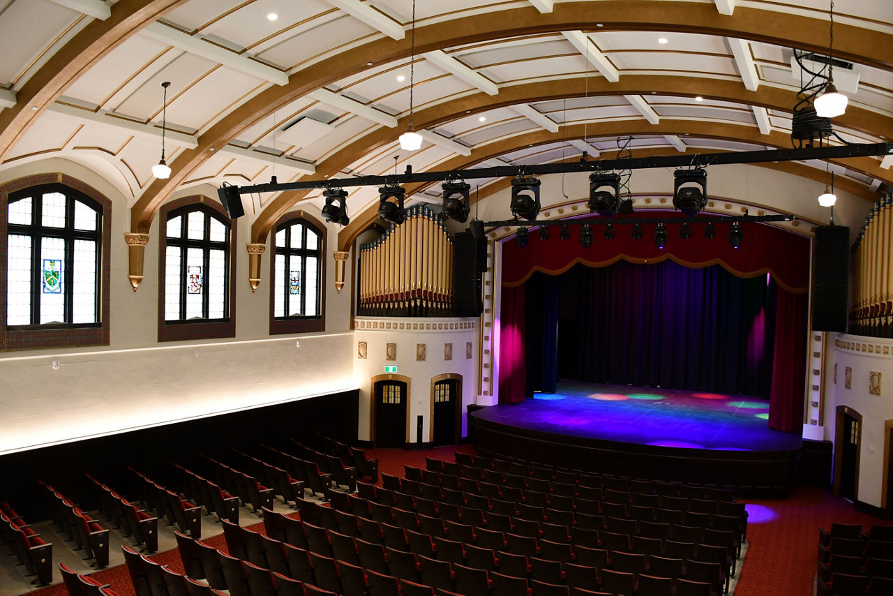 The interior of a college campus theater with stage lighting