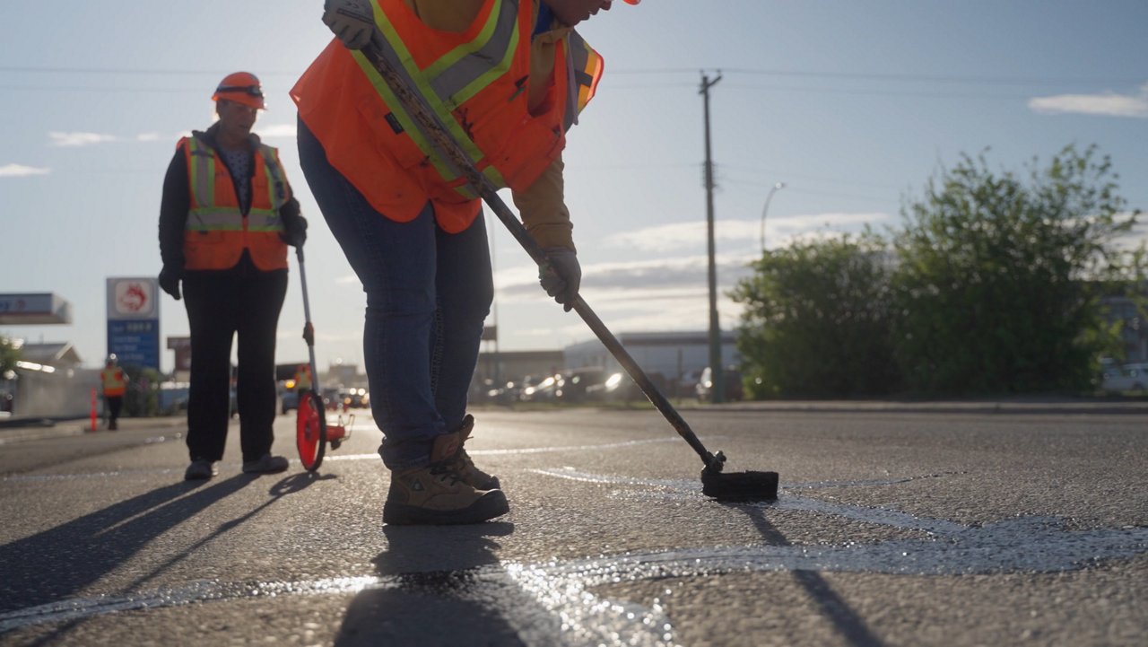 Ledcor Employee working on filling the cracks on the road.