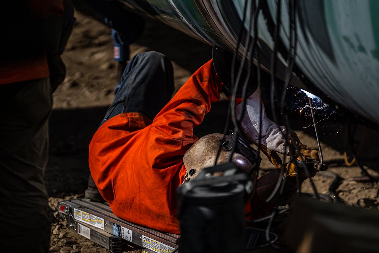 Welder working on pipeline segment