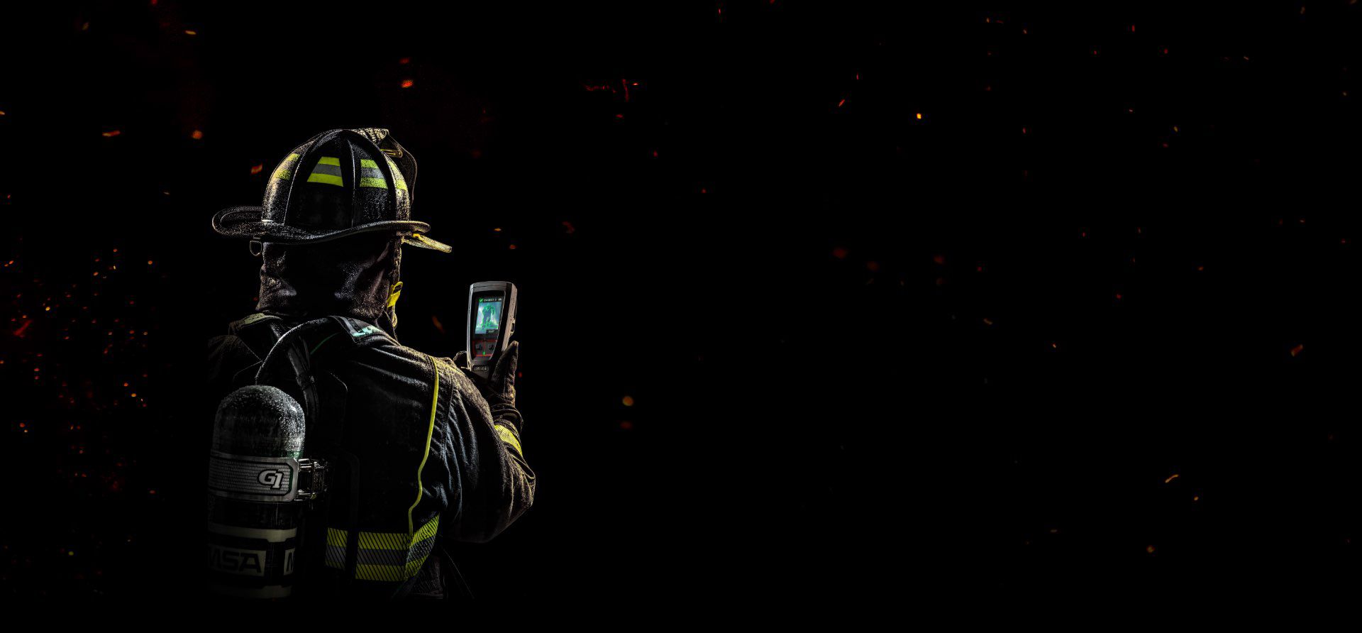 A firefighter holding Lunar, looking at the screen.