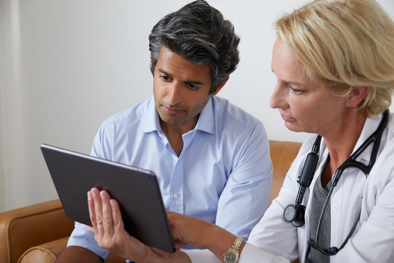 Female healthcare professional demonstrating the use of the Eko App on an iPad, wearing a Core Digital Stethoscope