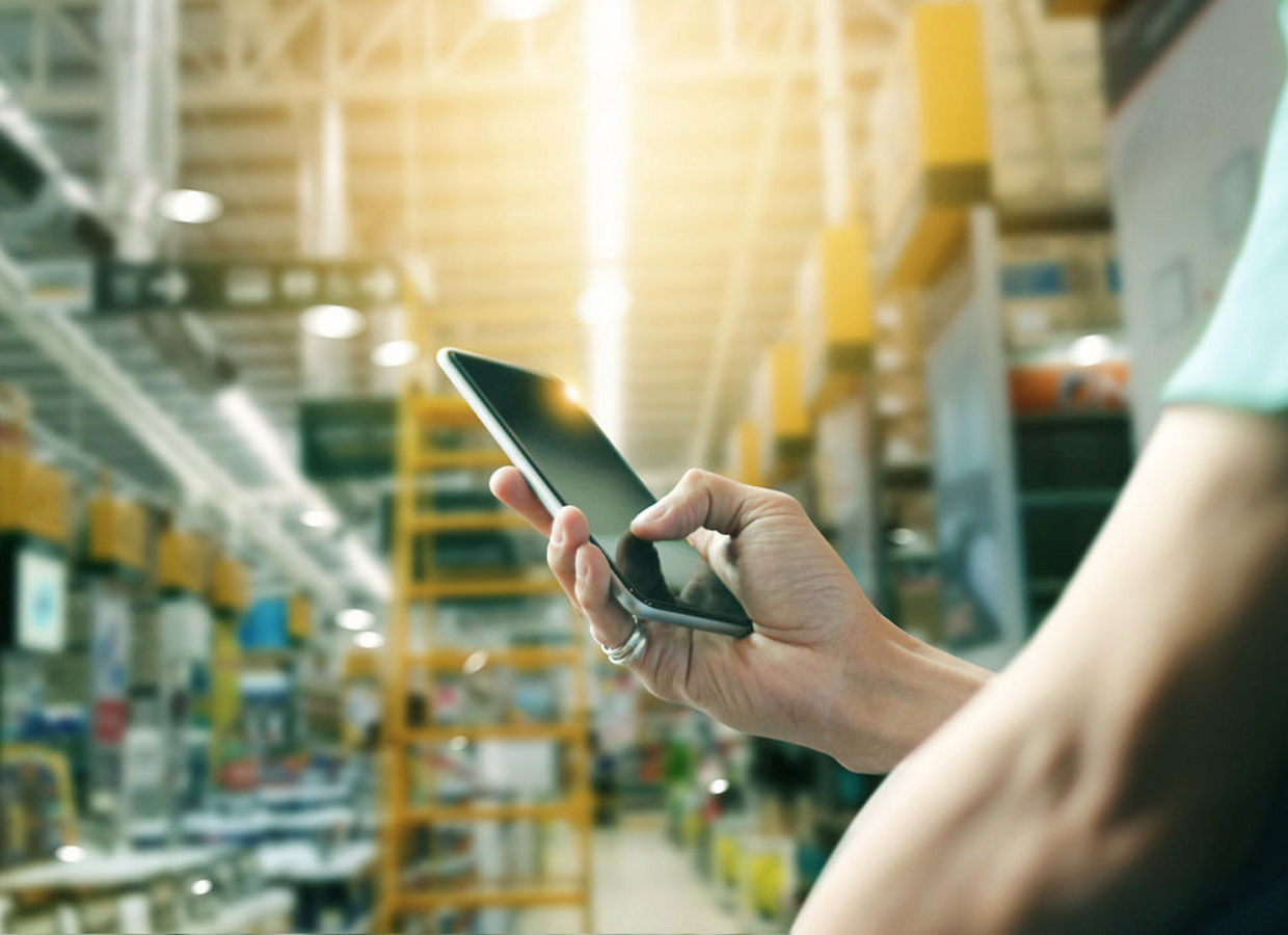 Factory worker using application on mobile smartphone to operate automation for modern trade.  Checking order in large warehouse.  Import and export the shipping cargo, Thailand