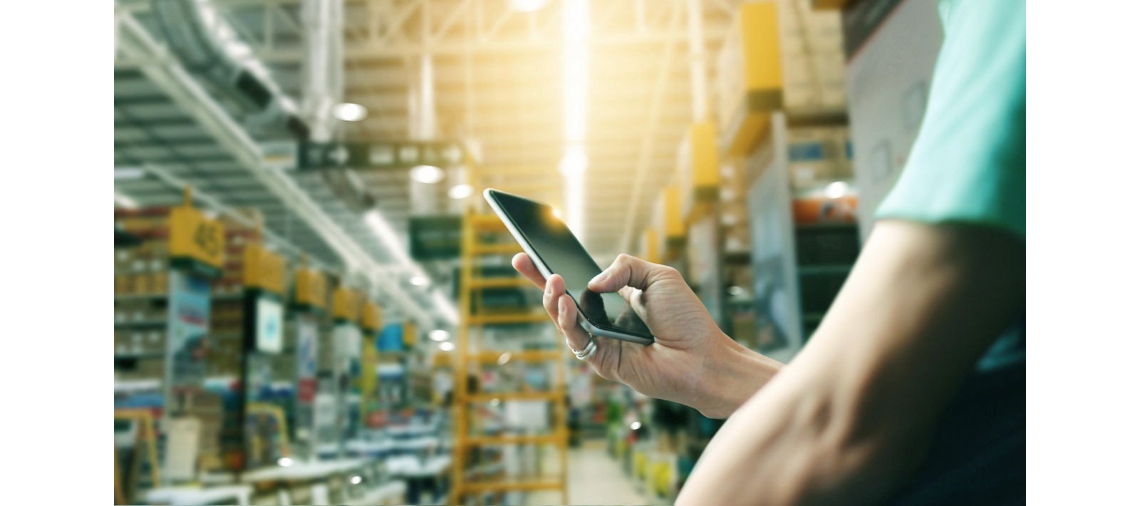 Factory worker using application on mobile smartphone to operate automation for modern trade.