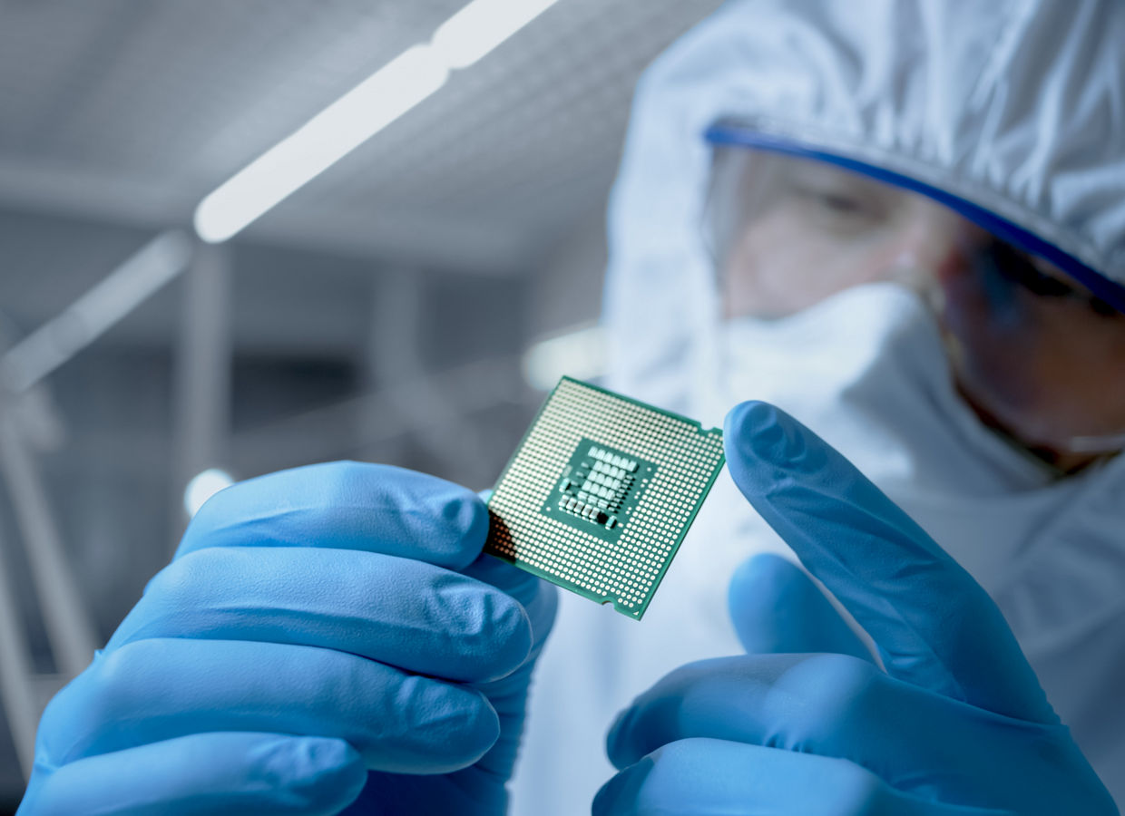 Selective focus of microprocessor in hand of scientist wearing latex glove