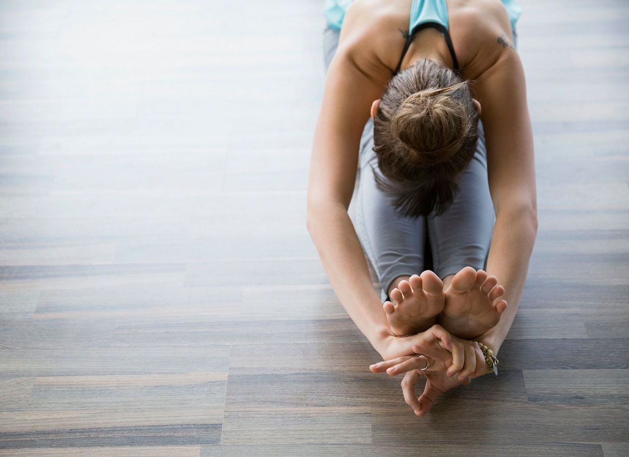앉아서 전굴 자세를 하며 무드라 요가를 하는 여성