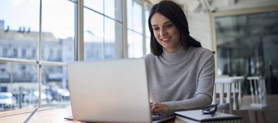 This asset is Shutterstock ID 626410799. This is licensed from Shutterstock Images. Unlimited seats were licensed there is no charge to use this image. Please download and use as needed, but include this Celum ID in Release Comments for new content loaded to Celum utilizing this asset. Title: Smiling attractive female freelancer doing remote job using laptop computer connected to wireless internet in office, professional administrative manager checking online business report documentation