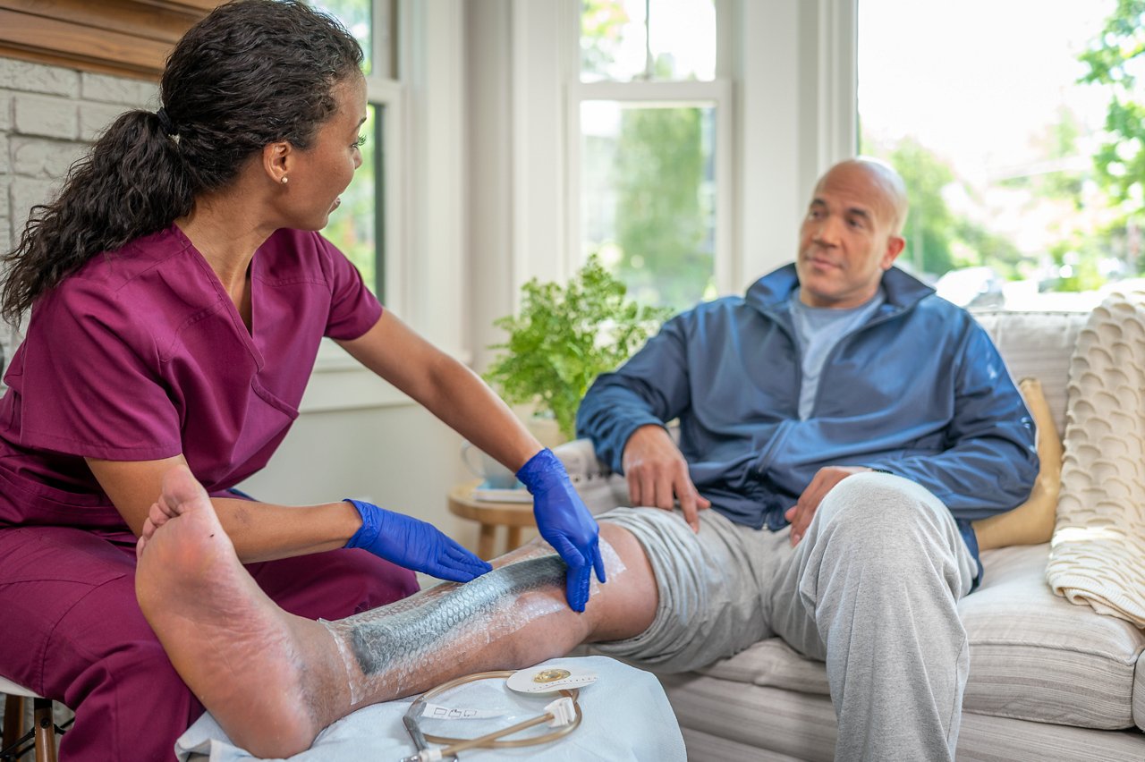 Patient zu Hause mit 3M™ V.A.C.® Granufoam™ Bridge Dressing/Dressing Kit auf die Wunde aufgetragen. Krankenschwester, die den Verband anlegt