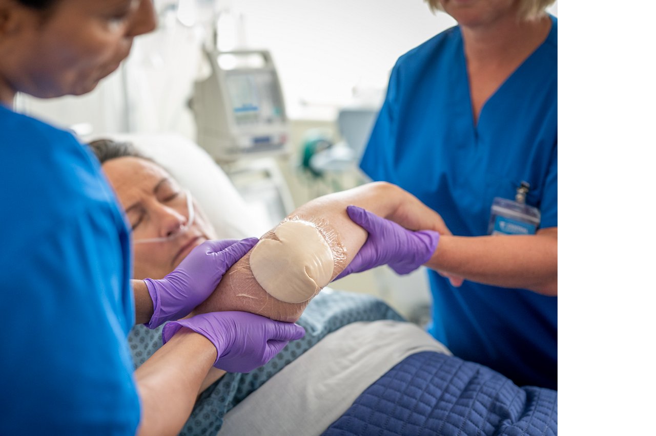 Clinician applying 3M™ Tegaderm™ Silicone Foam Dressing to elbow Photo 2
