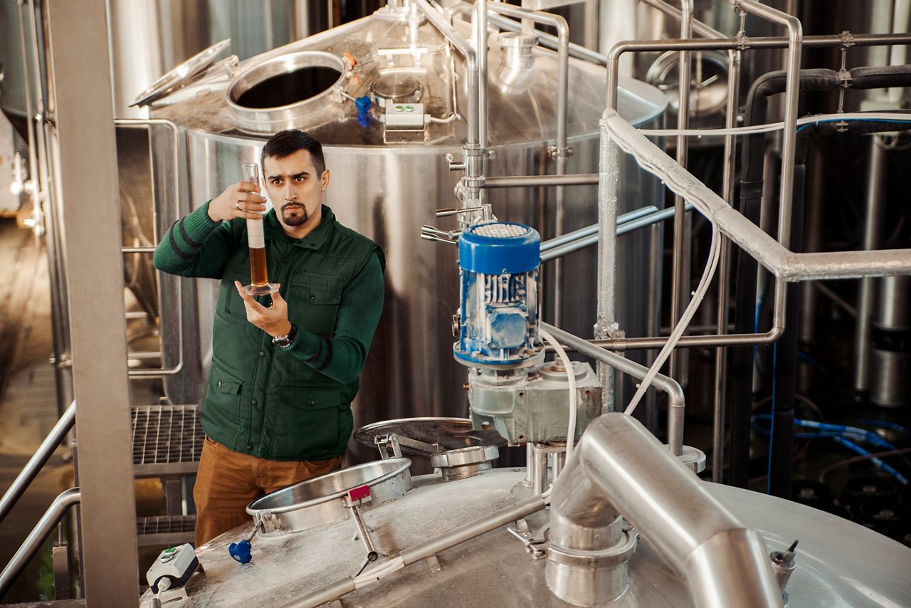 Young man working in craft brewery.