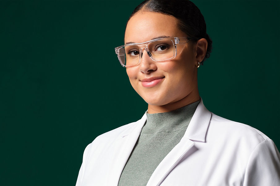 Female application engineer wearing white lab coat, safety googles and blue gloves