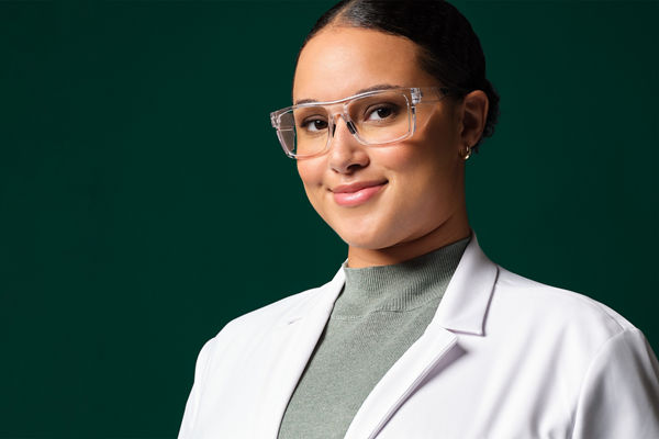 Female application engineer wearing white lab coat, safety googles and blue gloves