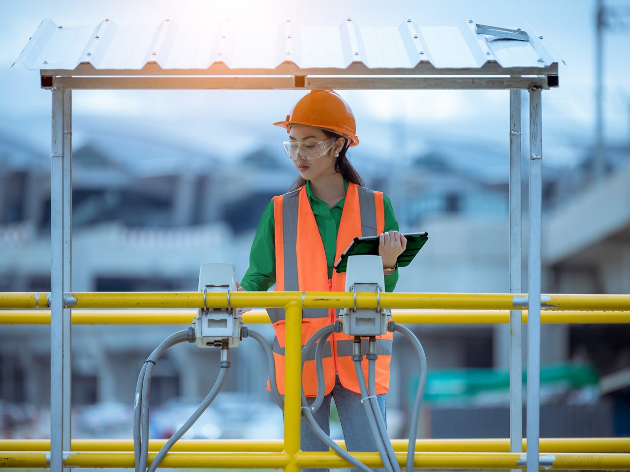 Female worker taking water from the wastewater treatment pond to check the quality of the water.