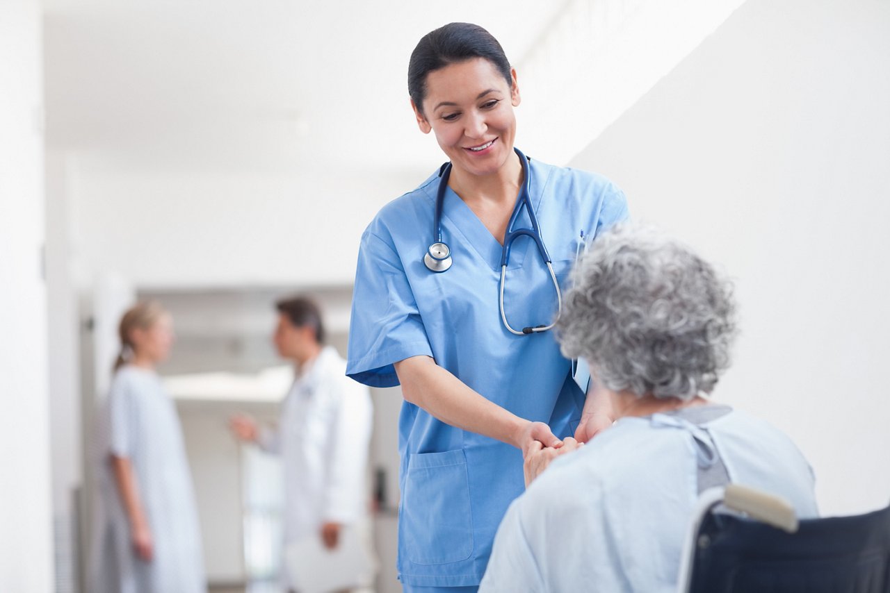 This asset is Shutterstock ID 106829282. This is licensed from Shutterstock Images. Unlimited seats were licensed there is no charge to use this image. Please download and use as needed, but relate this asset to the final assets utilizing this image. Title: Nurse standing next to a patient while holding her hands in hospital ward
