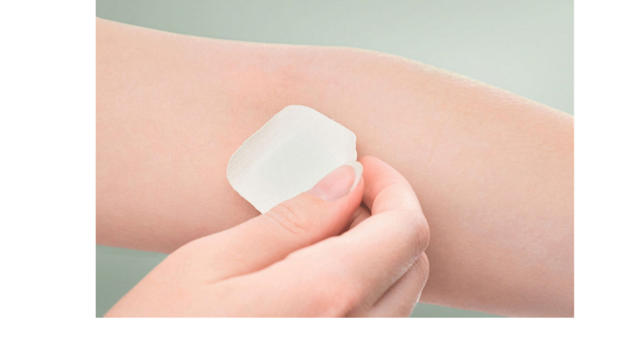 The girl sticks a patch on the elbow after giving blood from a vein. Concept for hospitals, laboratories, donation support