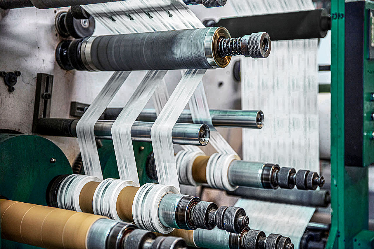 Rotatiesnijmachine met snijbladsysteem. Productie van ducttape. Verpakkingstapeproductie. Moderne machine voor verpakkingslijn in fabriek, industrieel en technologisch concept