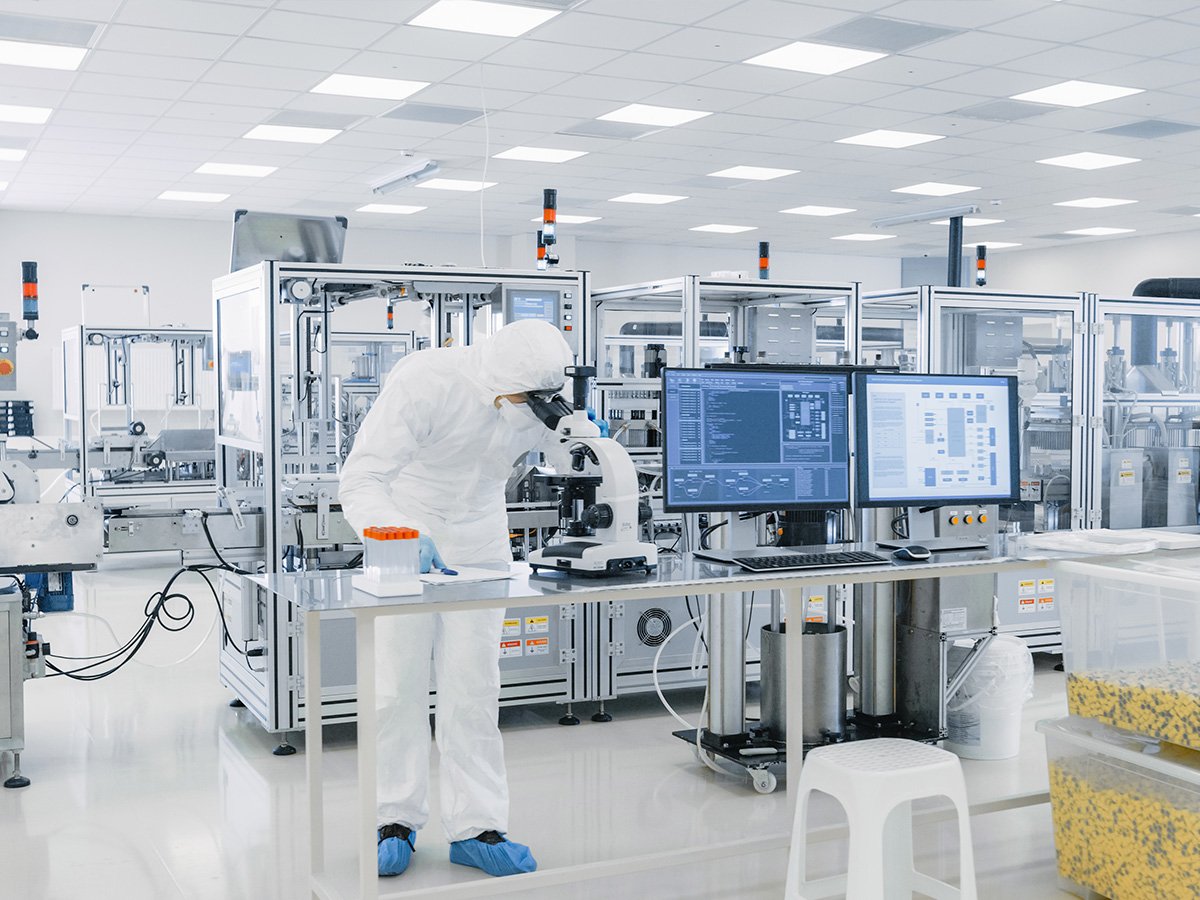 Shot of Sterile Pharmaceutical Manufacturing Laboratory where Scientists in Protective Coverall's Do Quality Control