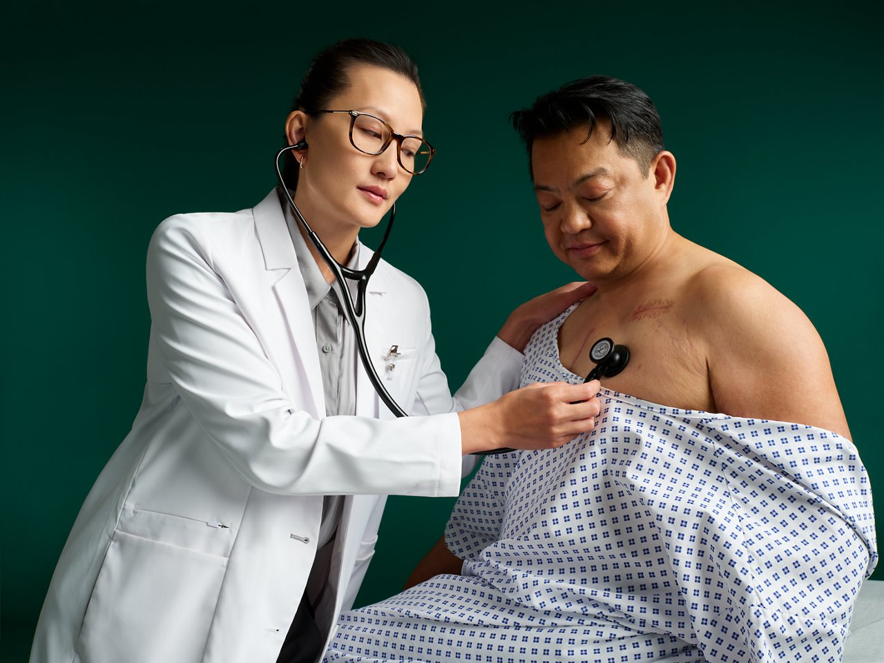 Cardiologist listening to a patient's chest with a Littmann stethoscope.