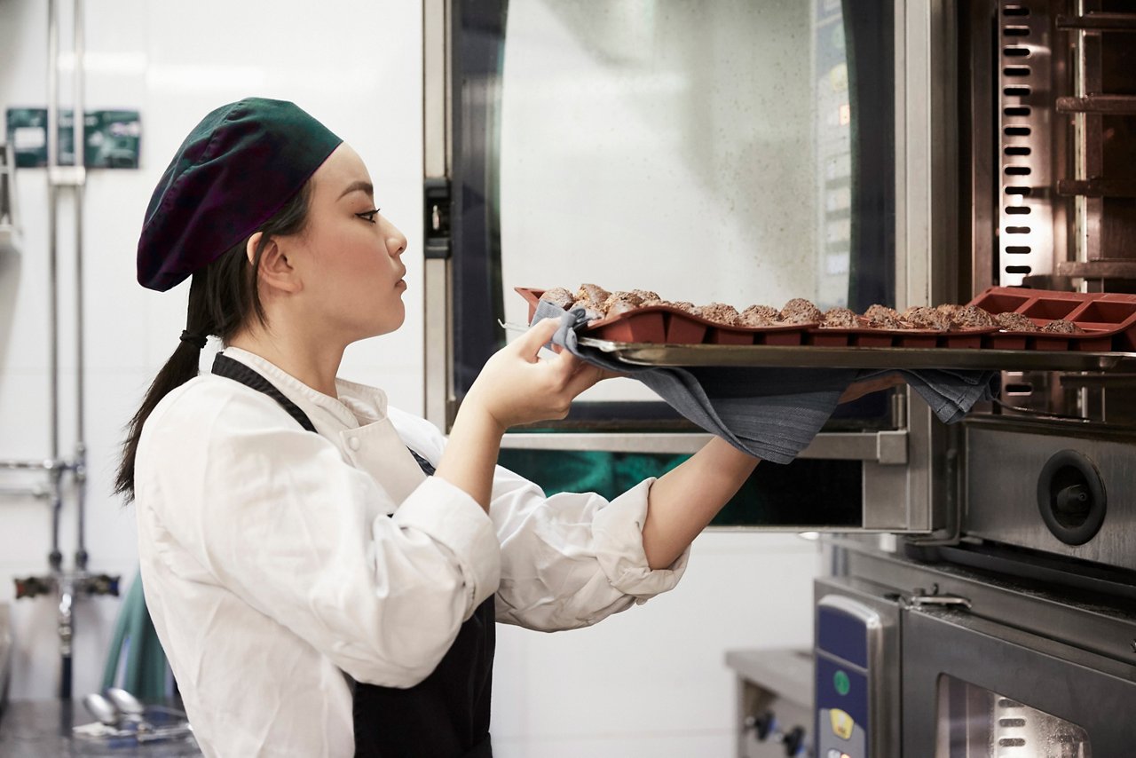 Woman placing a tray in the steam oven