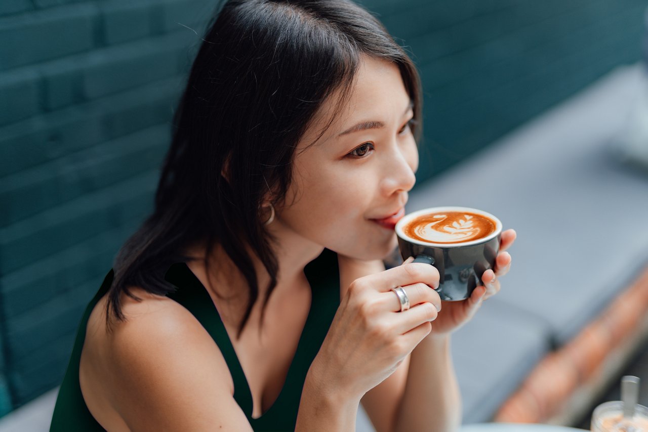 Asian woman enjoying a cappuccino