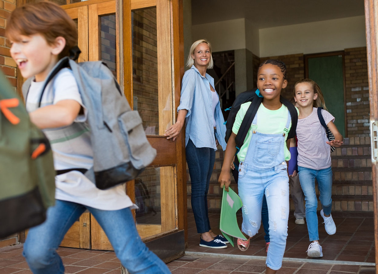 Group of elementary school children running outside at the end of the lessons.