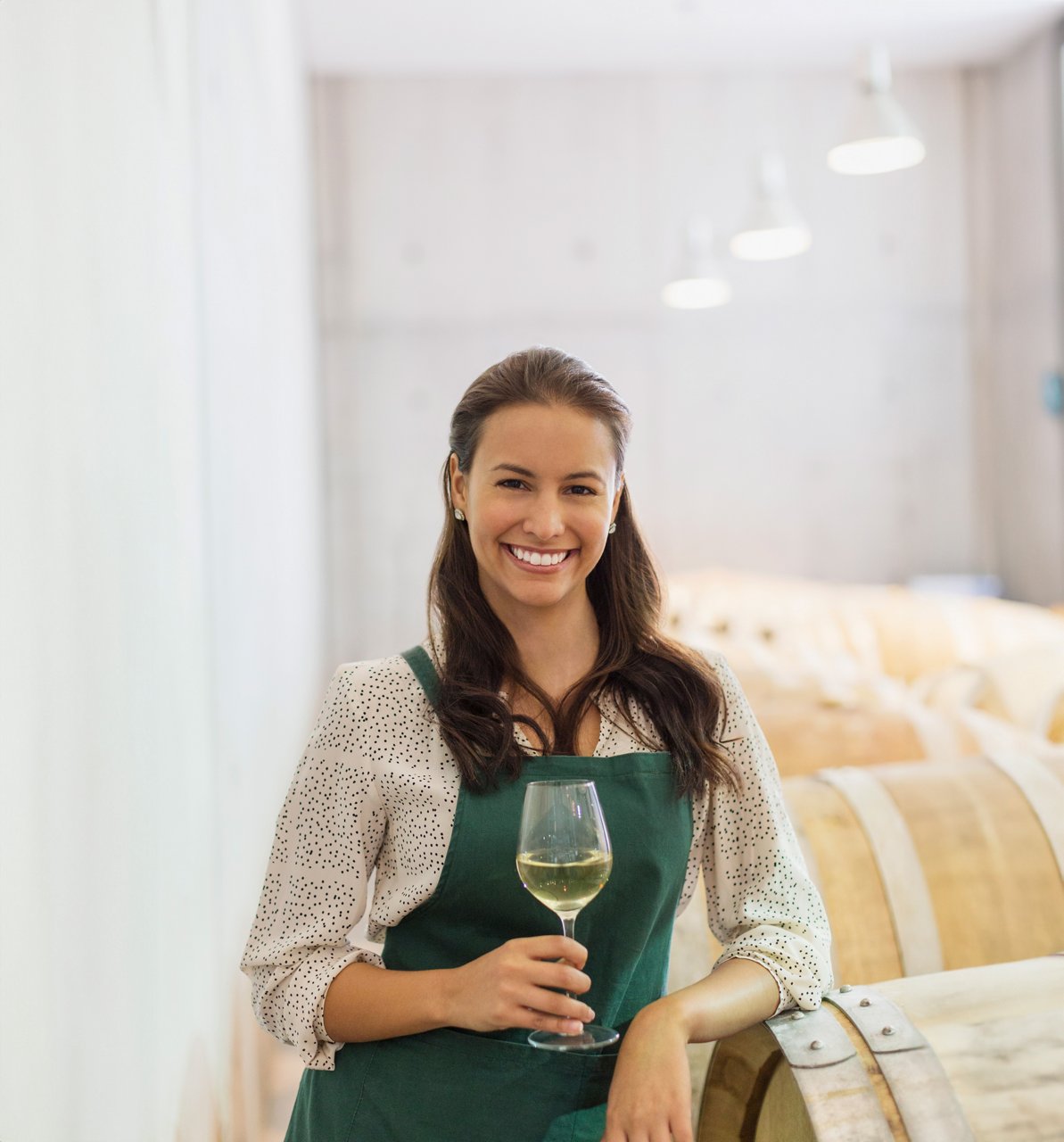 Portrait of a winemaker holding a glass of white wine