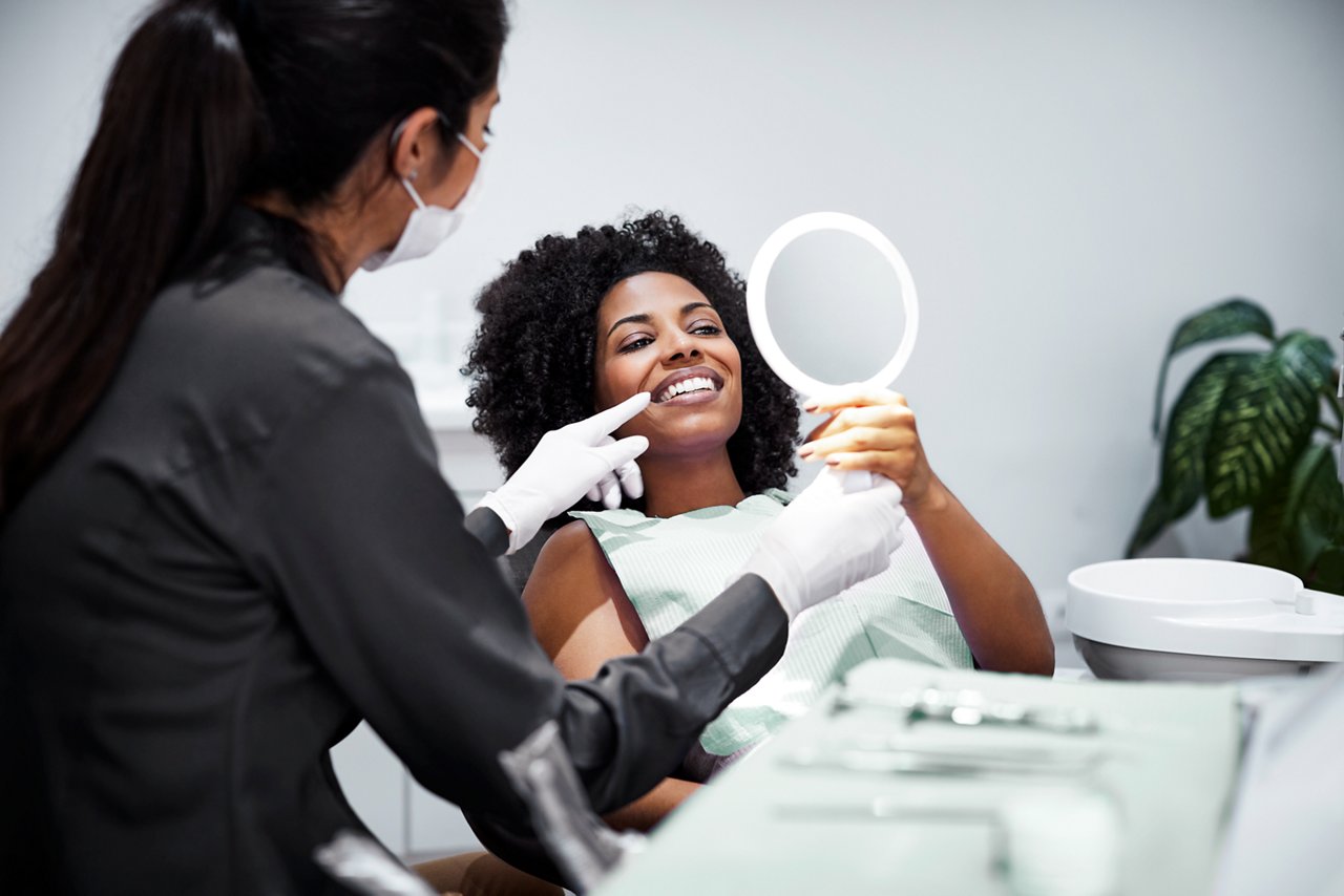 A female assistant talking with a female orthodontic patient